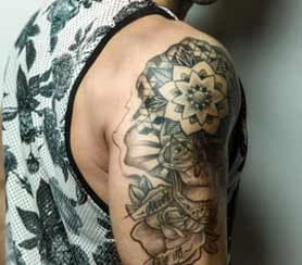 Shoulder with a black and gray mandala and roses